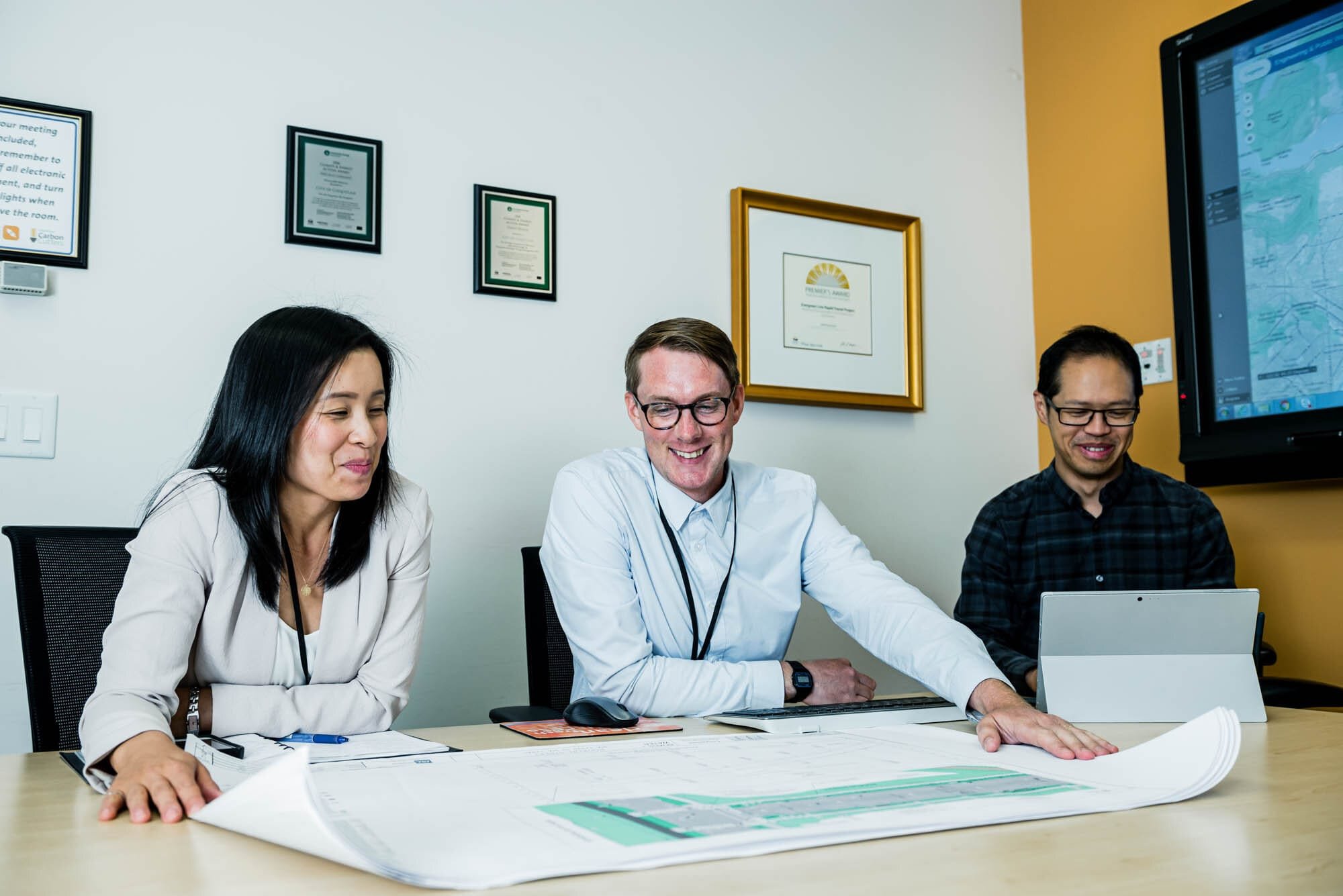 CoquitlamCityHR-6 Three professionals reviewing plans in a meeting room.