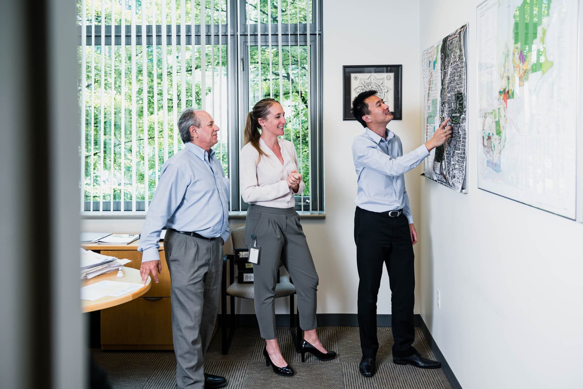 CoquitlamCityHR-9 Team discussing maps on office wall