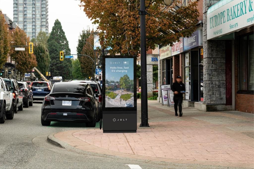 Street with free EV charging station sign.