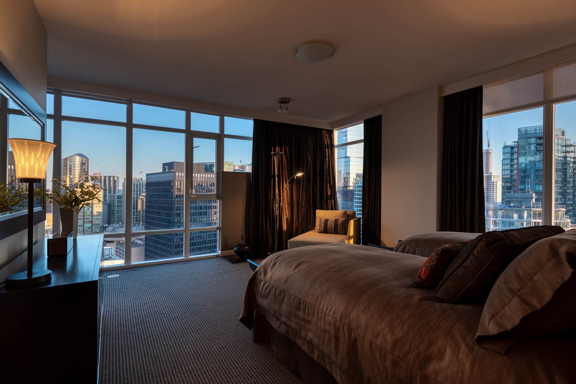 Coal Harbour Penthouse-8 City-view bedroom with modern decor at sunset