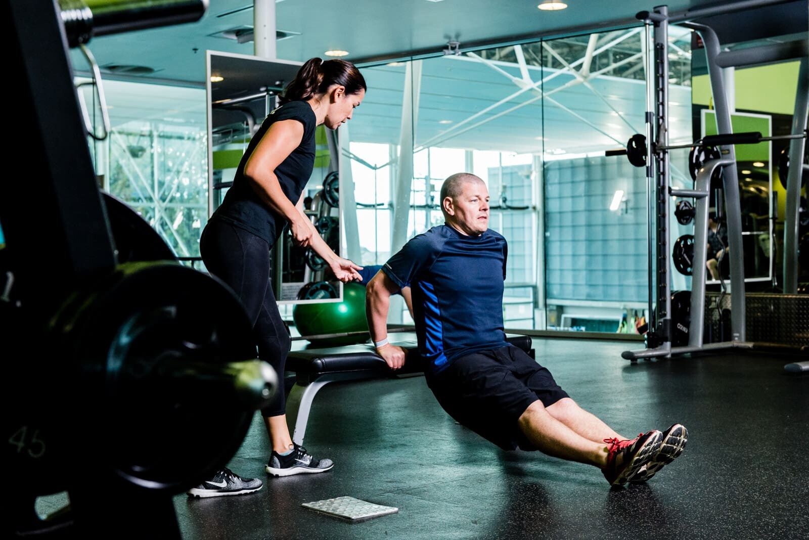 Personal trainer assisting gym workout