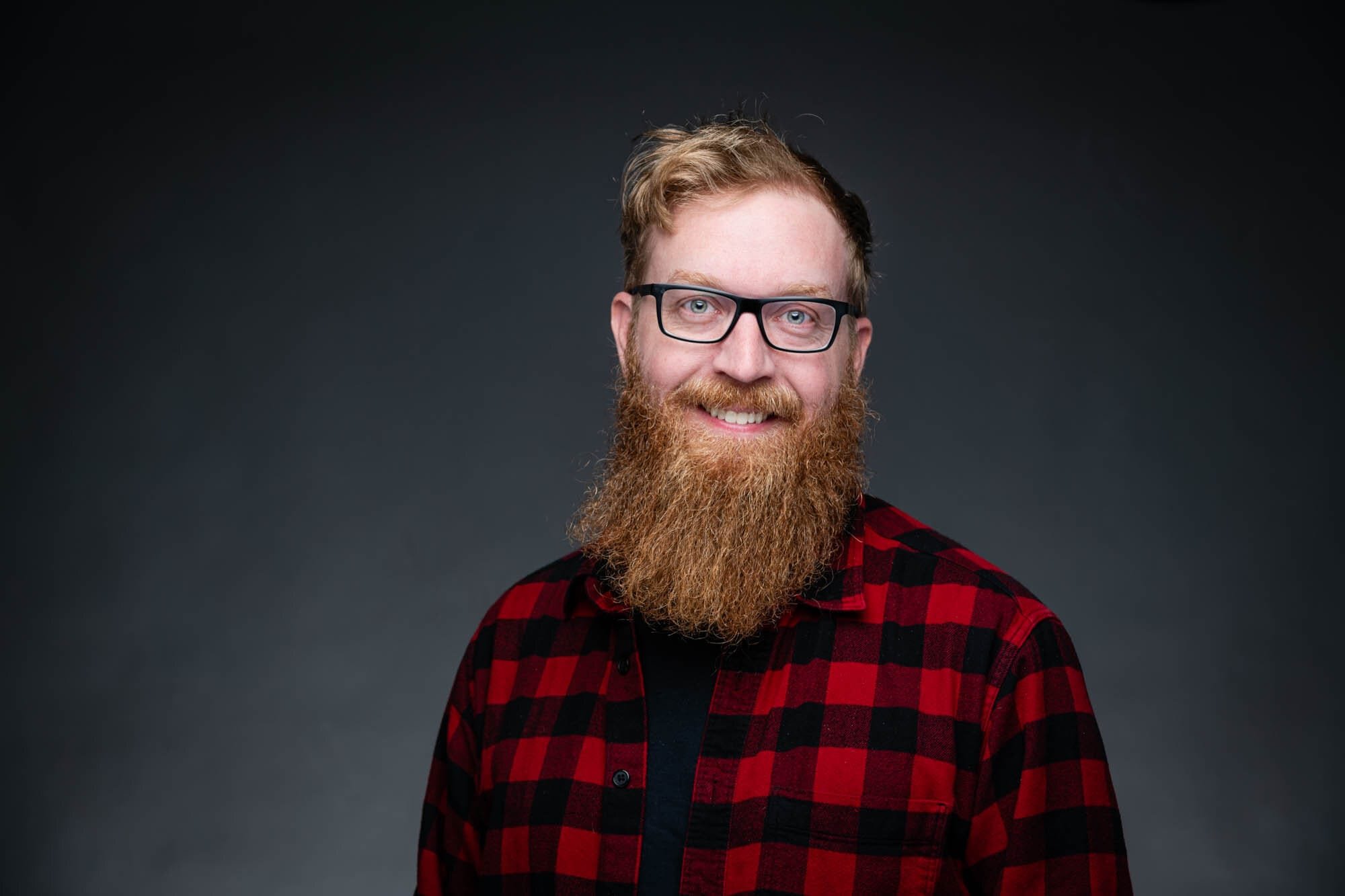GeaCongress Headshots-18 Man with red beard wearing glasses and plaid shirt