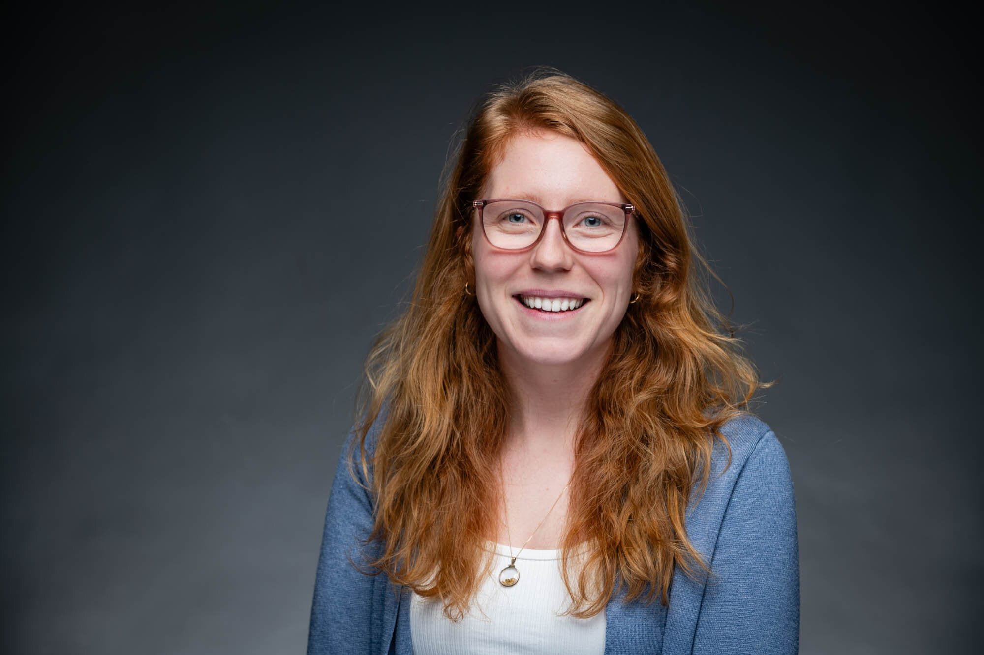 GeaCongress Headshots-23 Smiling woman with glasses and long red hair