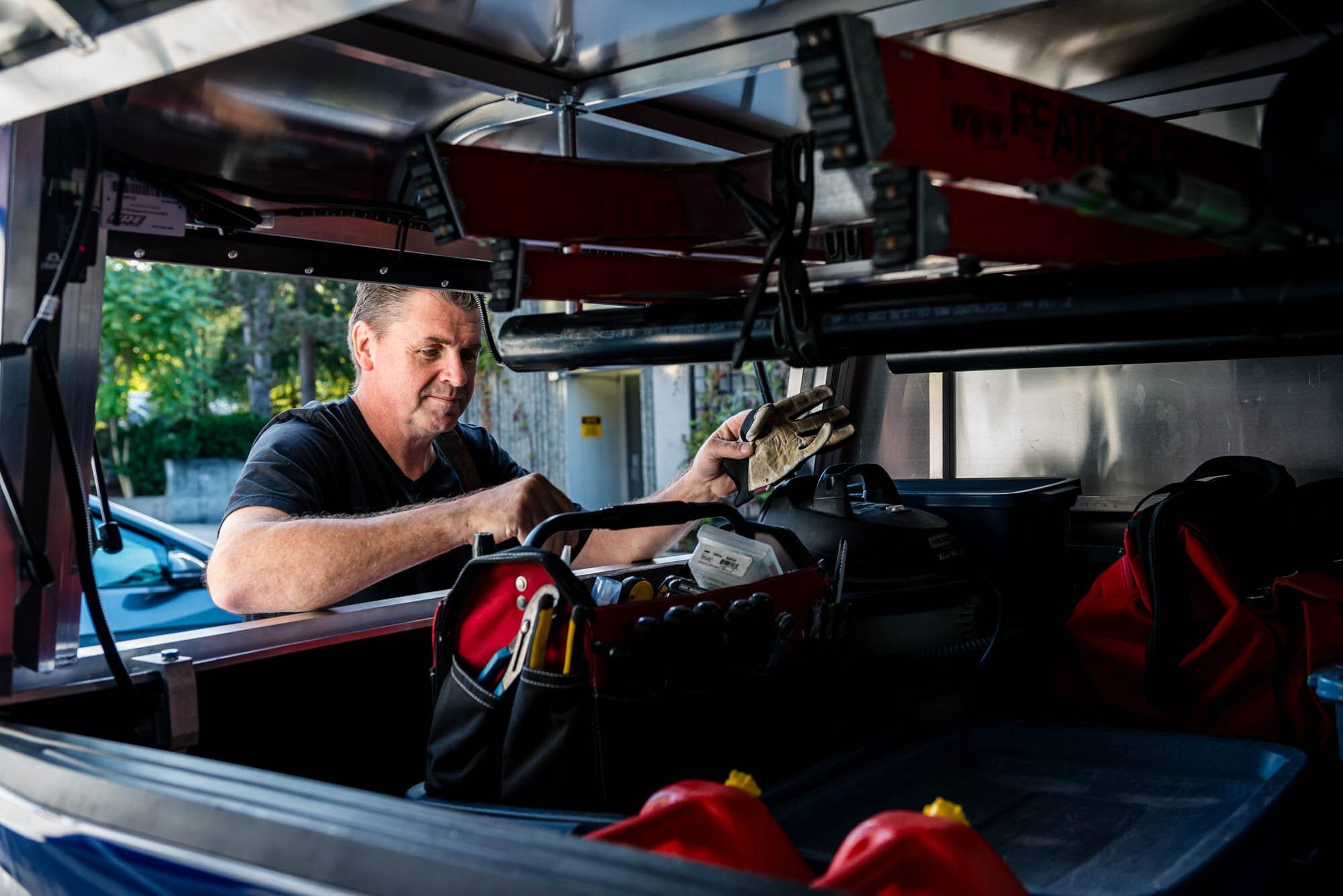 Rose Security-2 Man organizing tools inside a truck.