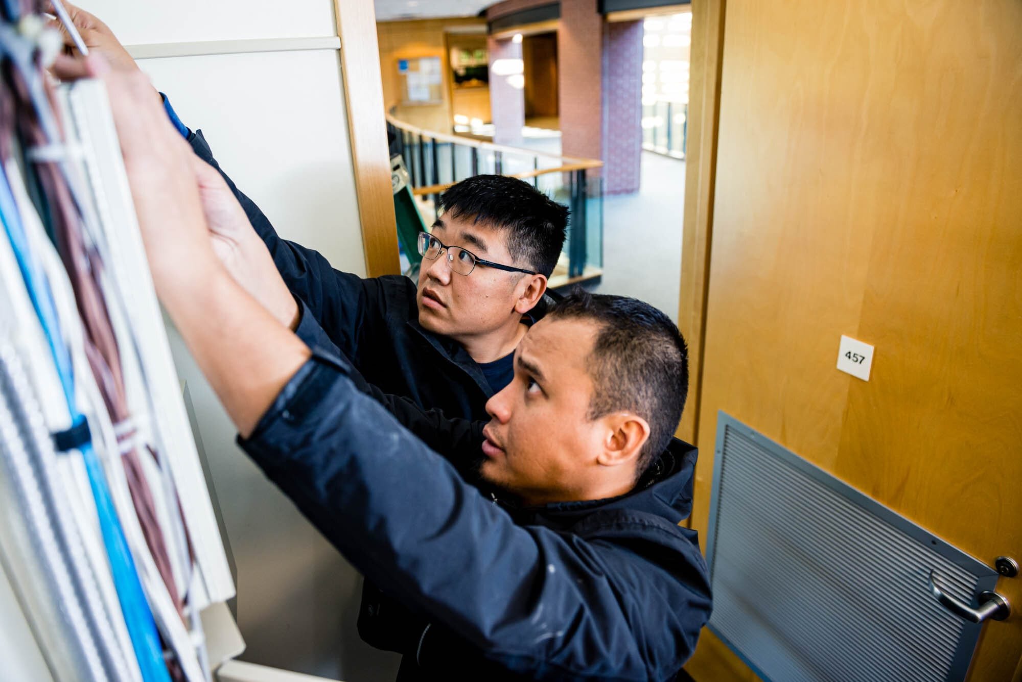 Rose Security-7 Two men inspecting electrical wires in office.