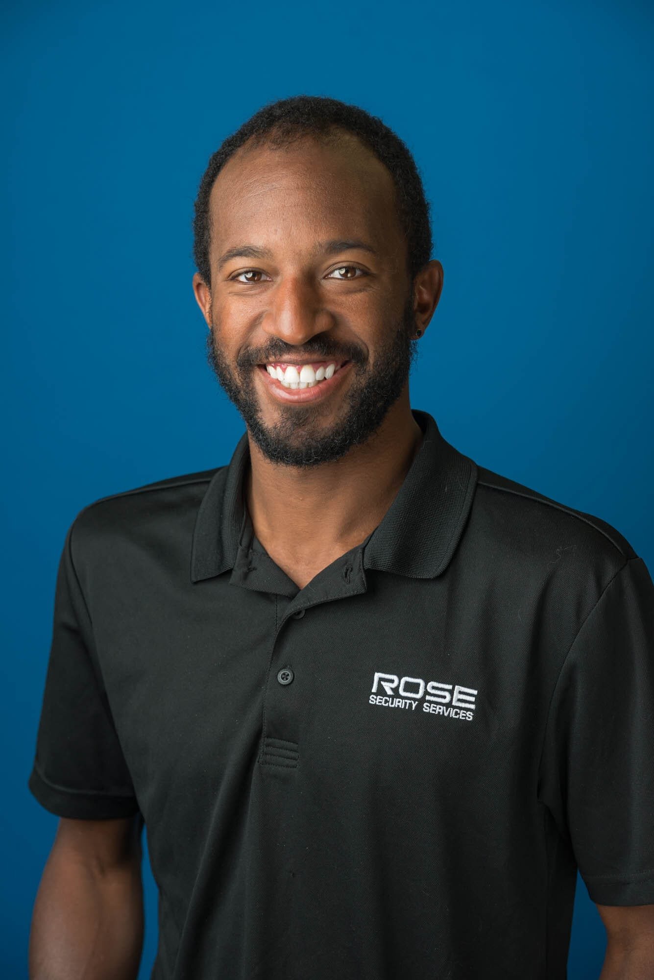 Rose Security Headshots-3 Smiling man in Rose Security Services shirt