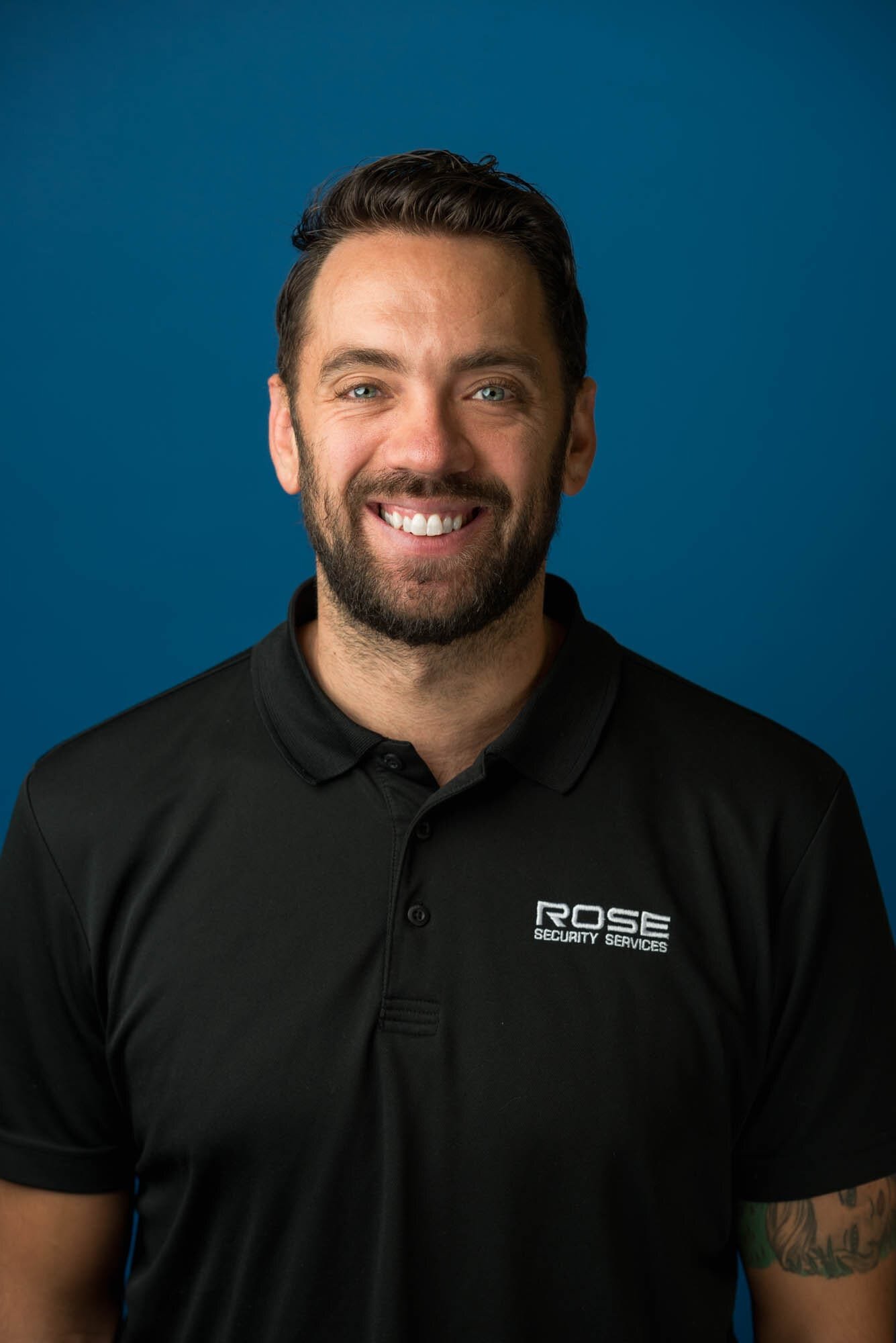 Rose Security Headshots-5 Smiling man wearing Rose Security Services shirt