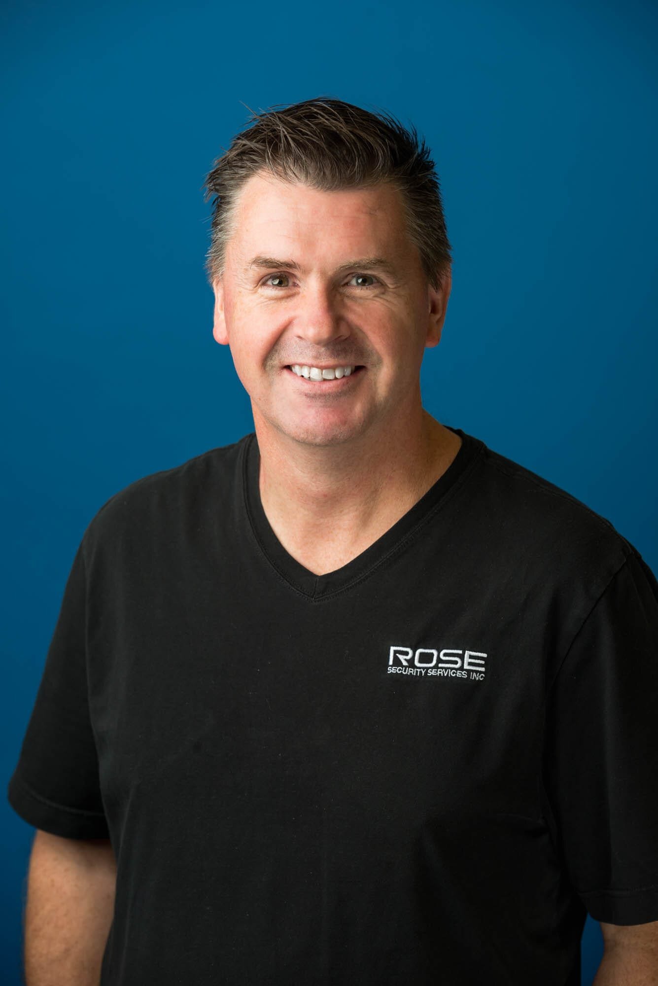 Rose Security Headshots-7 Smiling man in black Rose Security shirt
