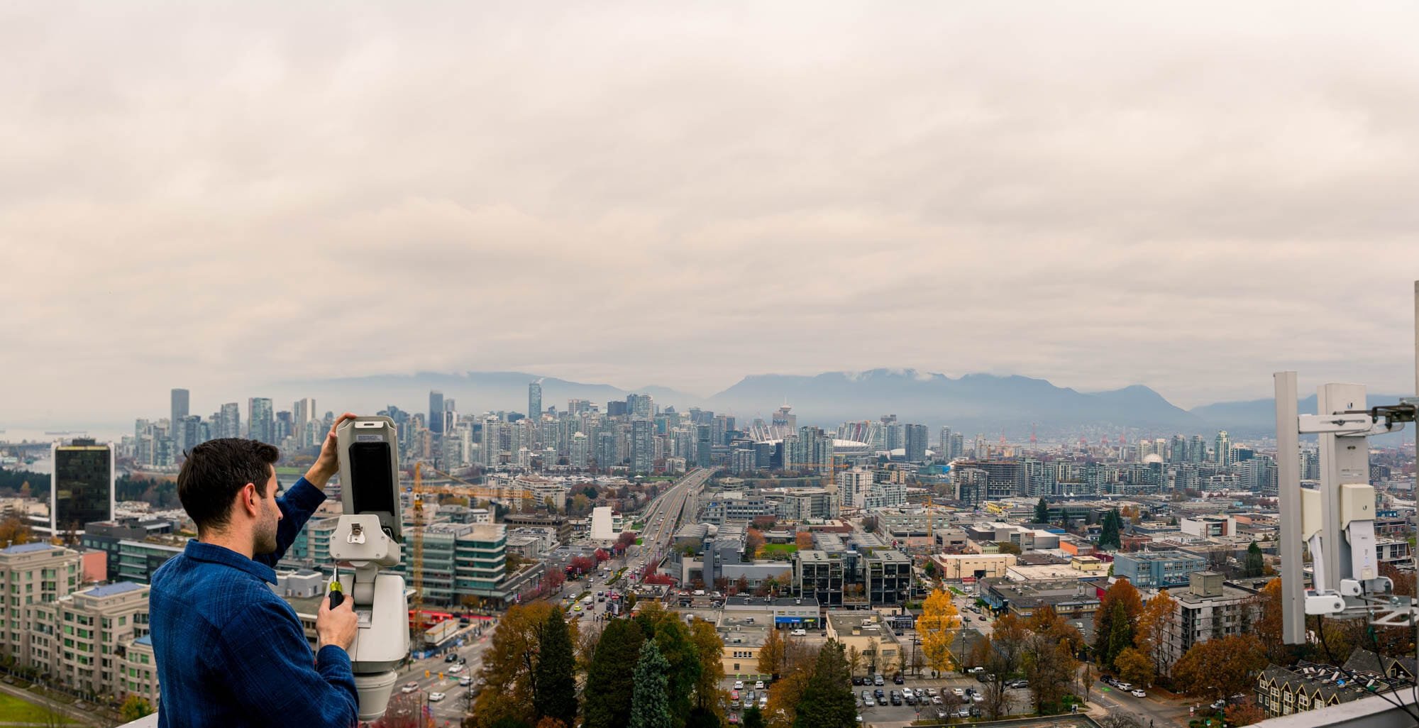 rose web banner-1 Man adjusting camera overlooking Vancouver cityscape