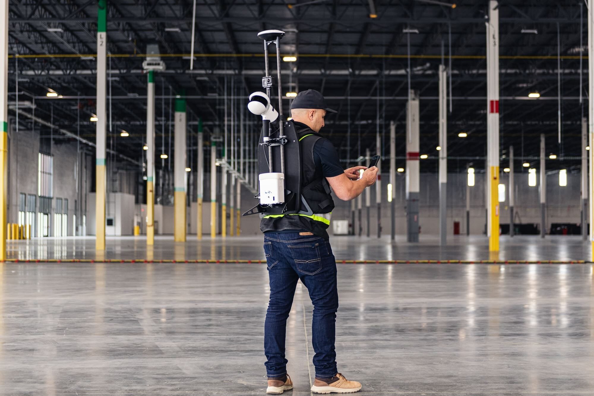 _BAP6659 Worker with survey equipment in large warehouse