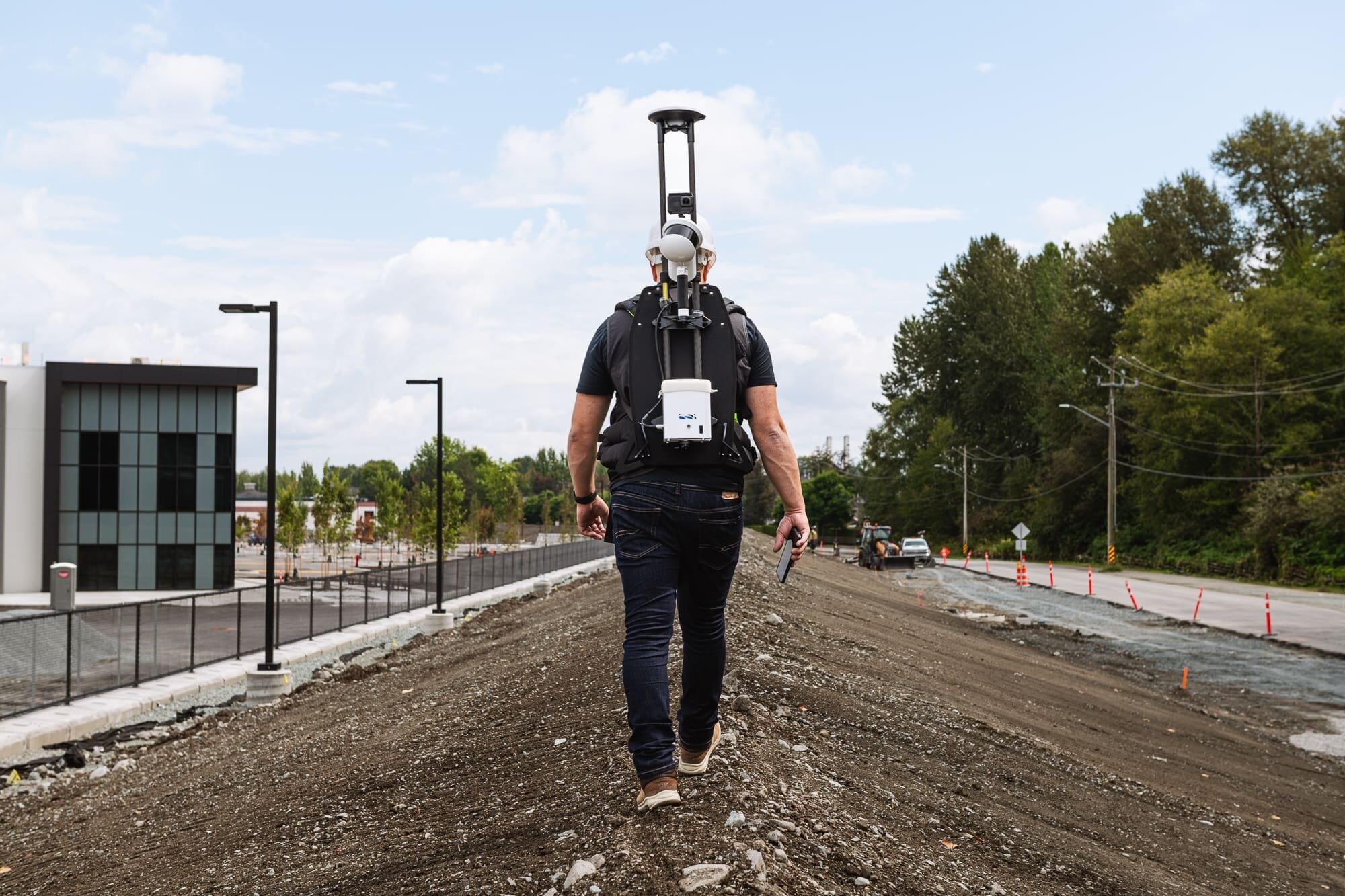 _BAP6906 Surveyor walking with lidar mapping equipment on construction site.