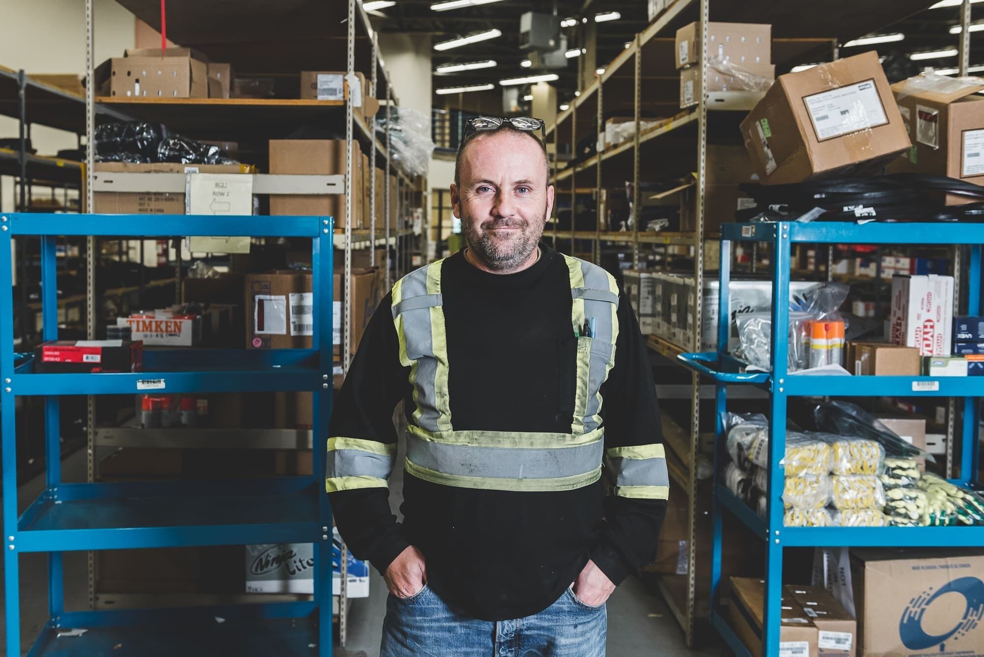 BAP_2736 Warehouse worker standing between shelves.