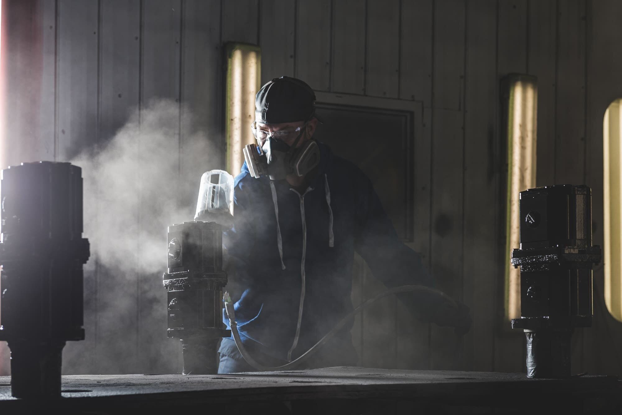 BAP_4242 Person in mask spray painting in industrial setting