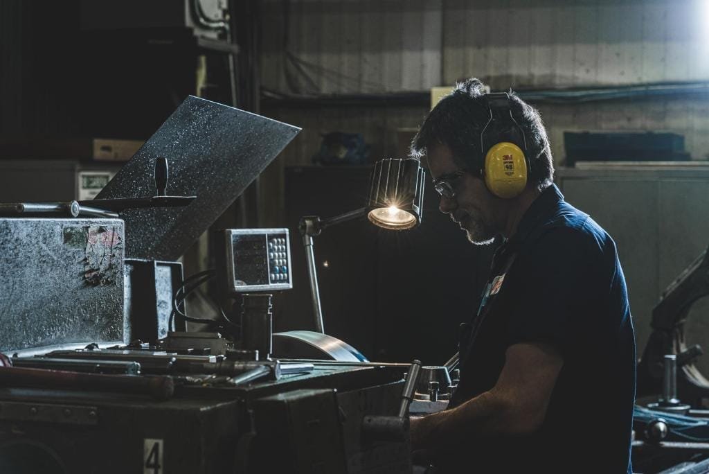Man working at industrial machine with safety gear