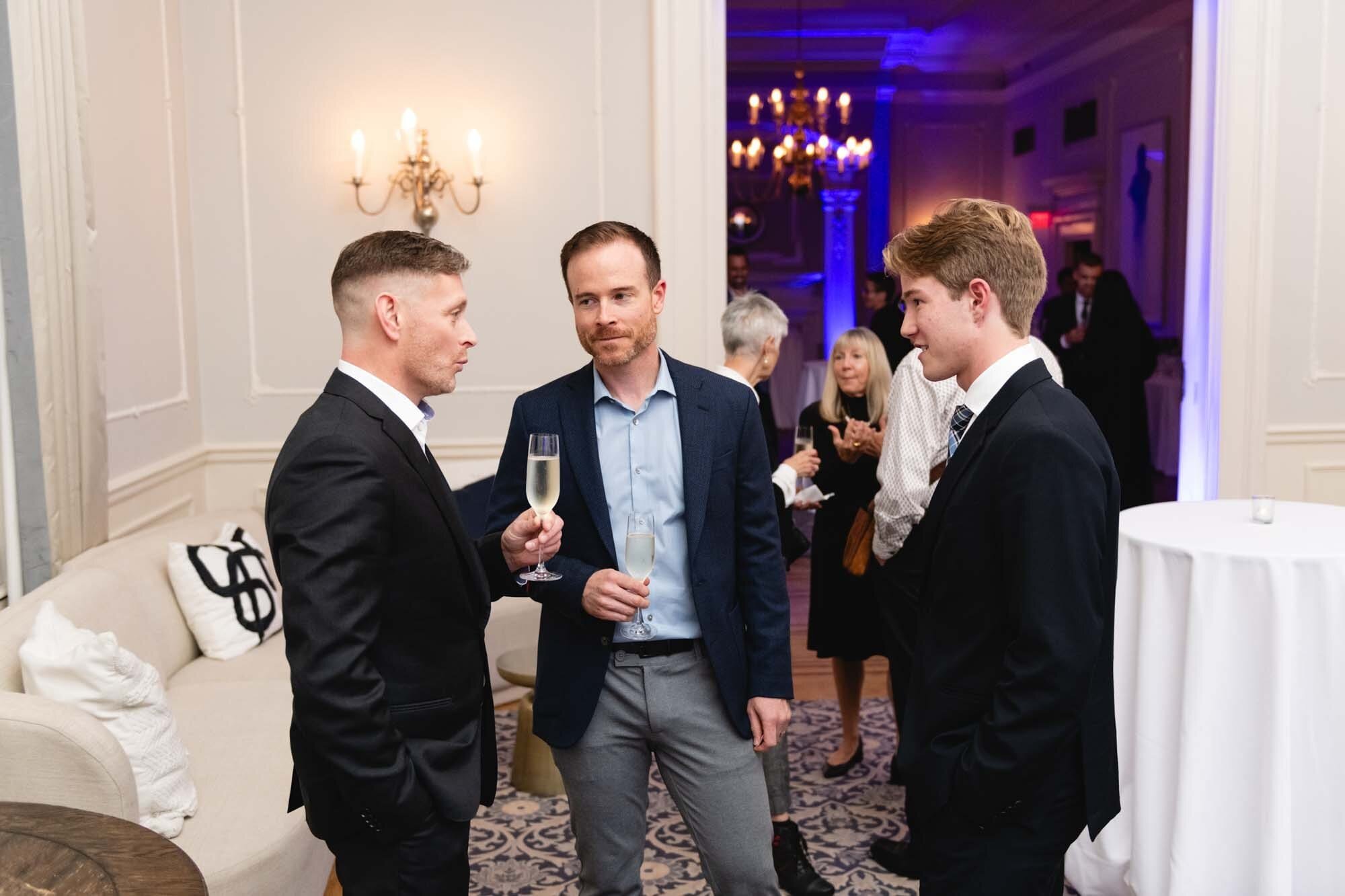 West Light Media Event Photography-63 Men in suits conversing at a formal event.