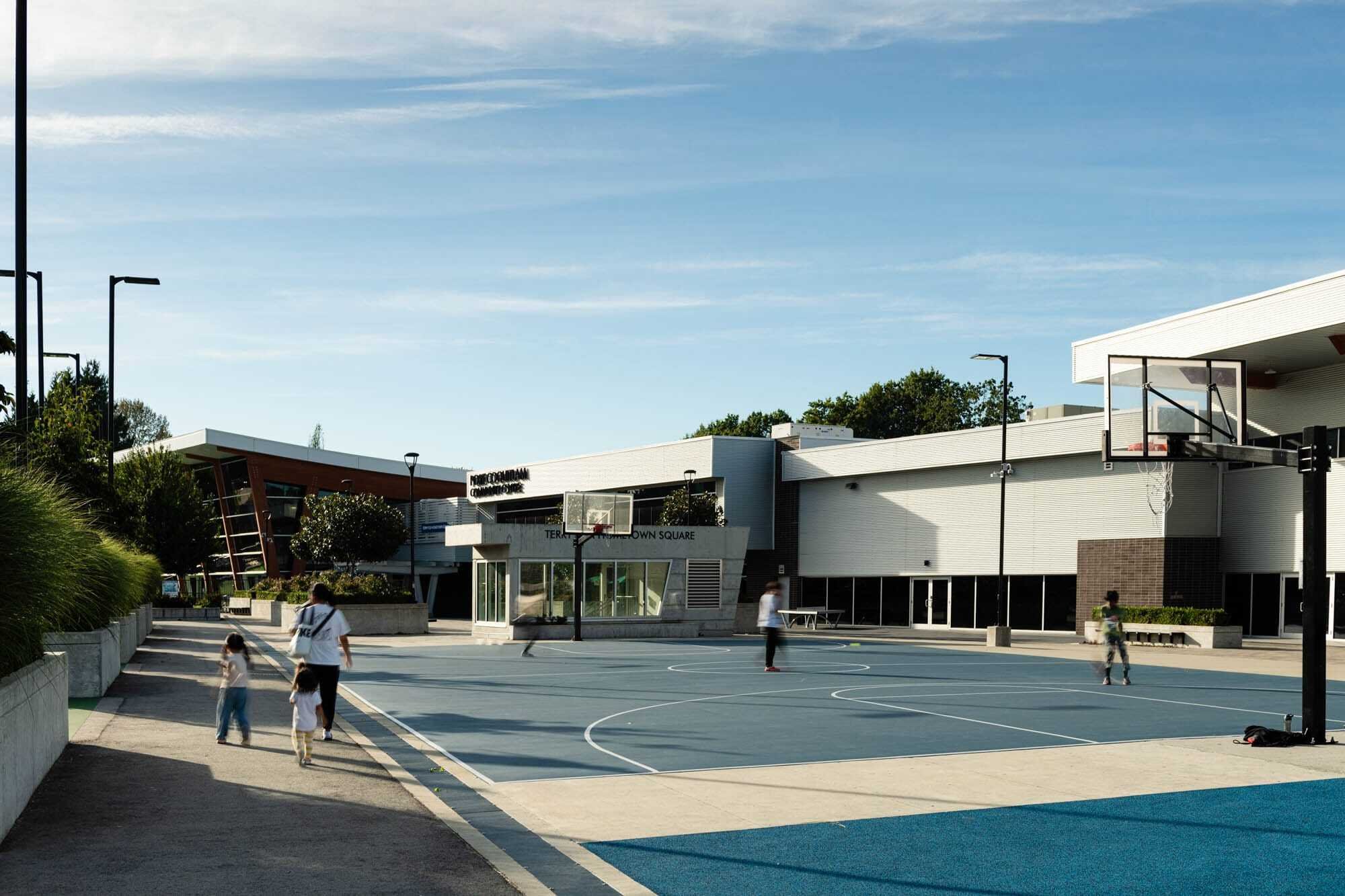 Jolt Charging-4 Outdoor basketball court with people playing and walking.